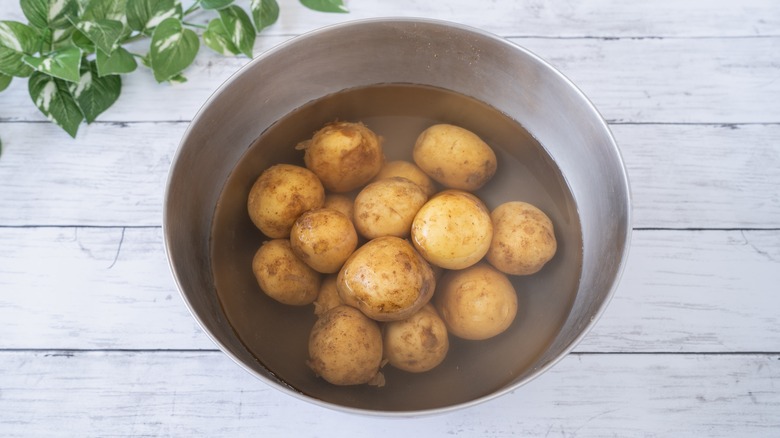 soaking potatoes in bowl of water