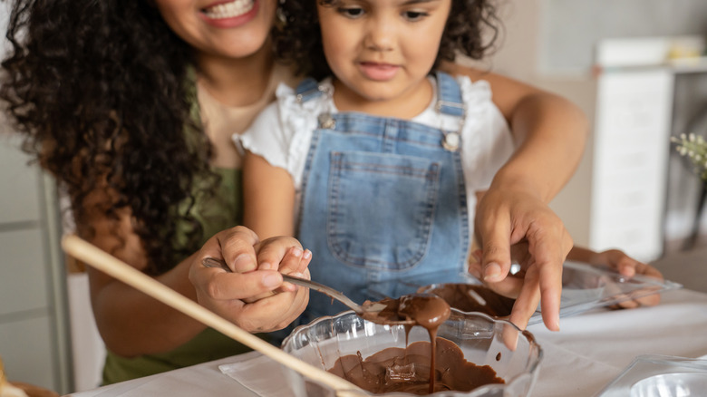 A mother and daughter working with melted chocolate