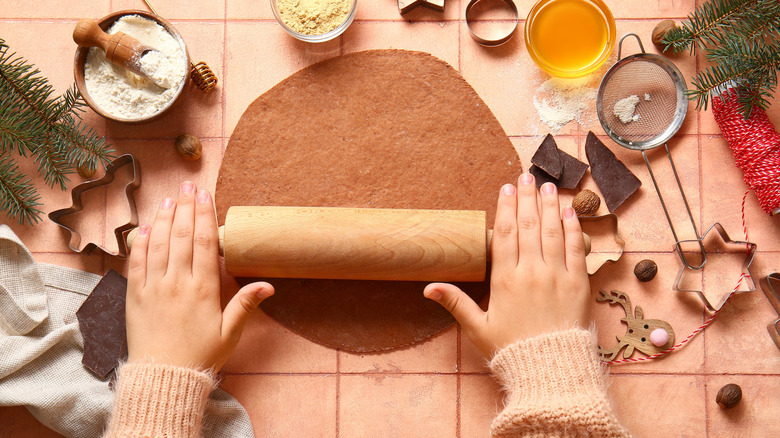 A person rolling out gingerbread dough