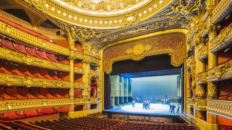 Paris Opera House interior with empty audience and people on stage.