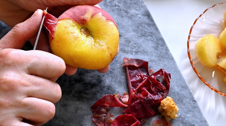 Peach being peeled with skins on table