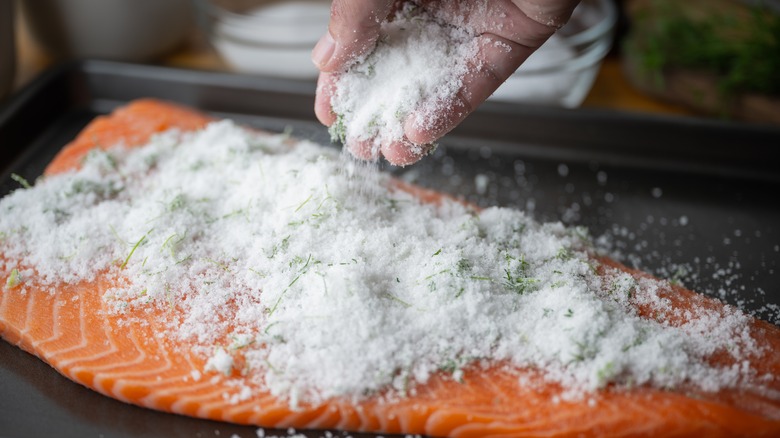 adding salt to salmon to make gravlax 