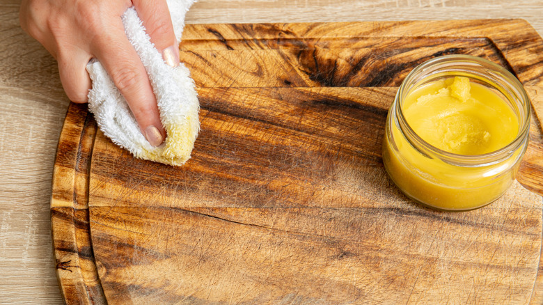 Person using beeswax to treat a cutting board