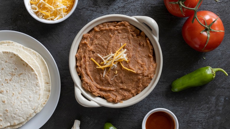 Refried beans in bowl with tortillas