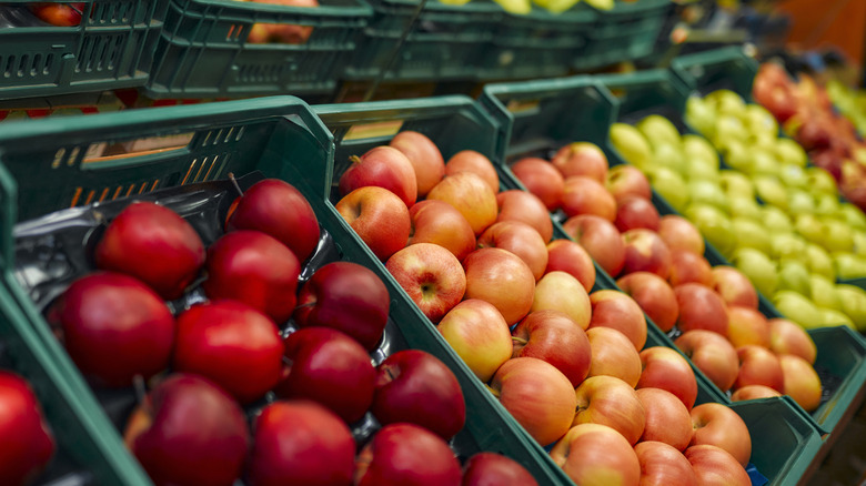 Bins of red, pink, and green apples.