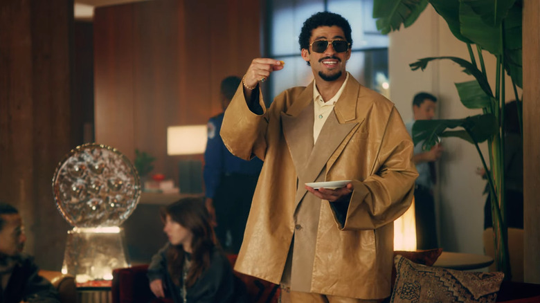 Bad Bunny smiling with white plate and crackers.