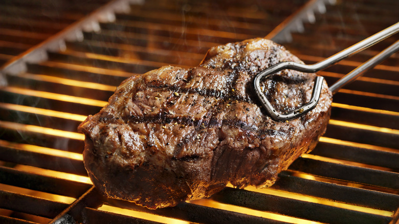 Steak being flipped on a grill