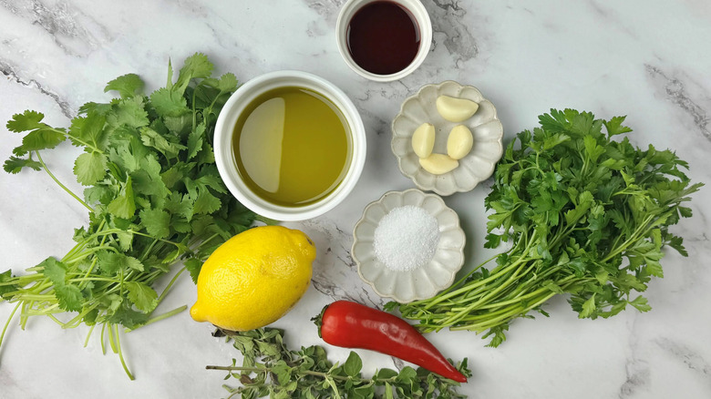 Ingredients for chimichurri on a marble counter