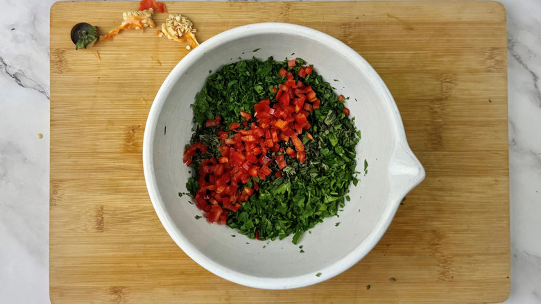 Minced herbs and diced red chile in bowl