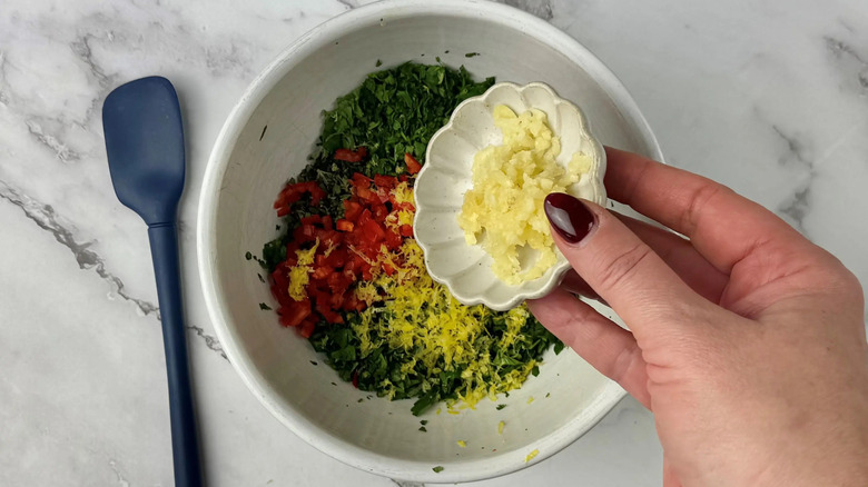 Small bowl of garlic pouring into larger bowl