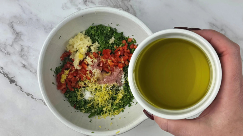 Small bowl of olive oil over larger bowl of chimichurri