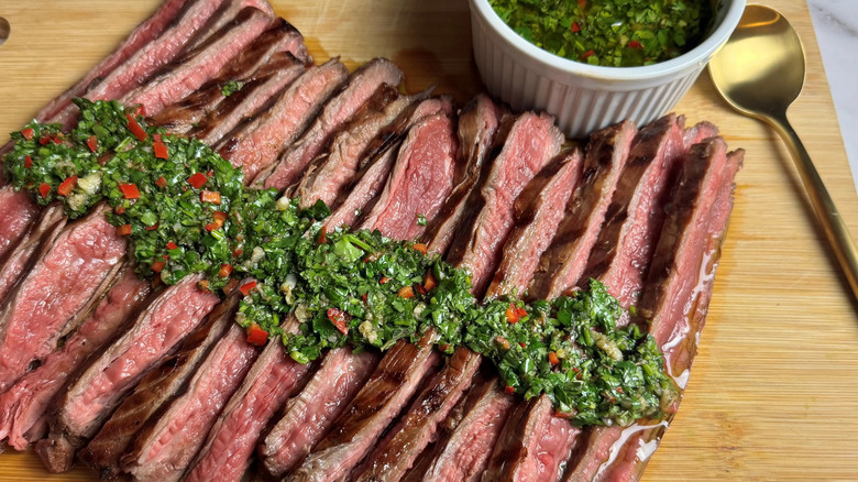 Chimichurri drizzled across sliced steak