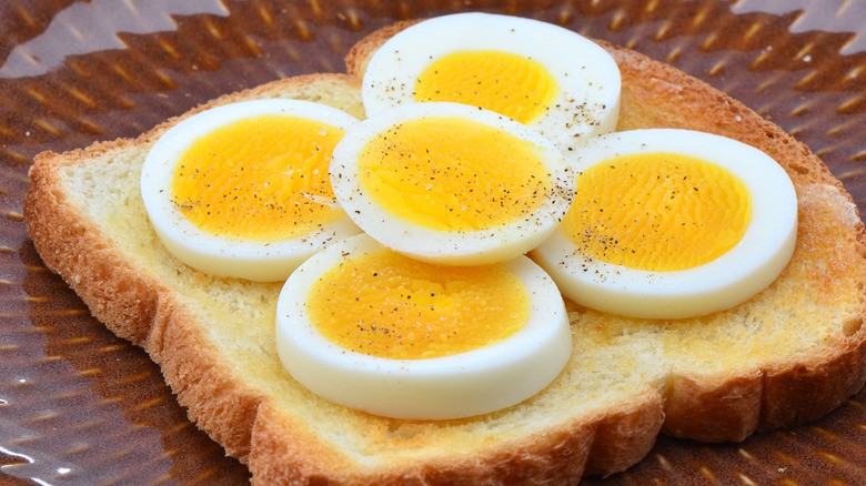 Hard boiled eggs on toast with salt and pepper sprinkled on