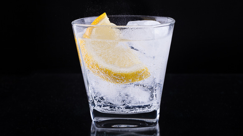 Clear liquid in a glass with a slice of lemon