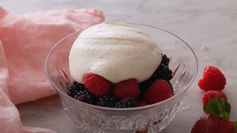 Mound of whipped cream on berries.