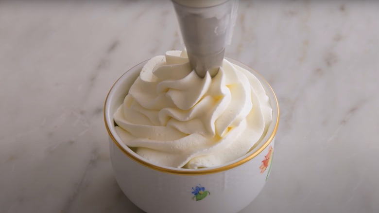 Whipped cream piped from nozzle 