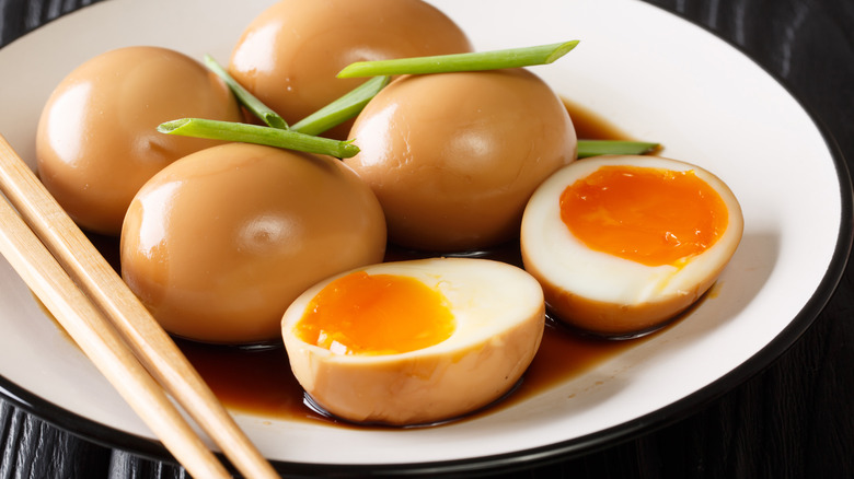 Halved and whole soy marinated ramen eggs