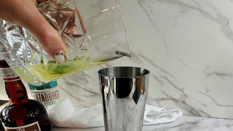 Lime juice and jalapeño pouring into cocktail shaker