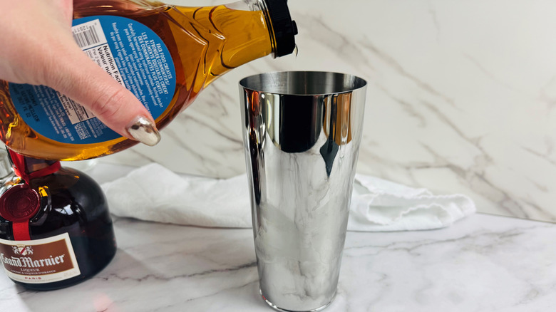 Hand pouring agave nectar into cocktail shaker