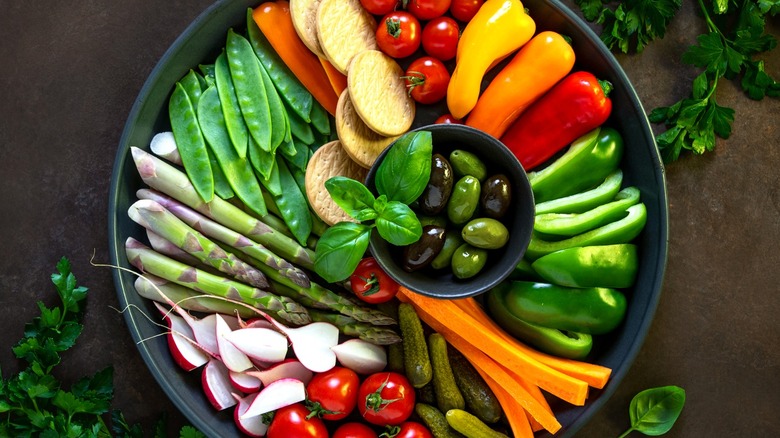 A platter of colorful vegetables and fresh herbs