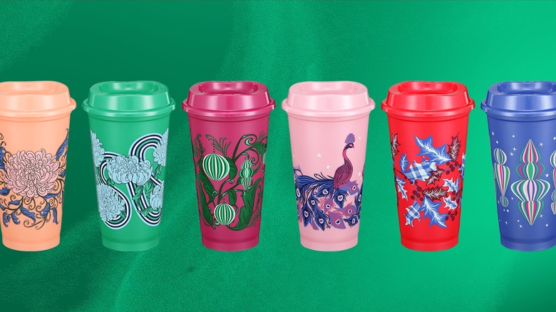 Six color-changing tumblers from Starbucks 2024 holiday drinkware collection on textured green background.