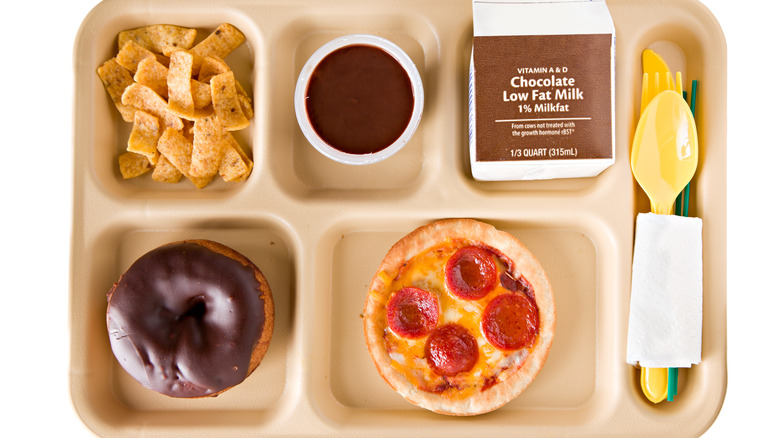 School lunch tray with chips, doughnut, small pepperoni pizza, and chocolate milk