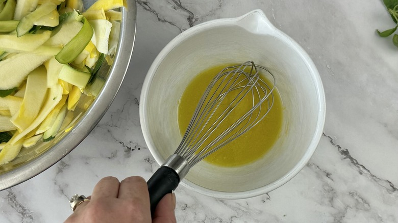 whisking vinaigrette ingredients in bowl