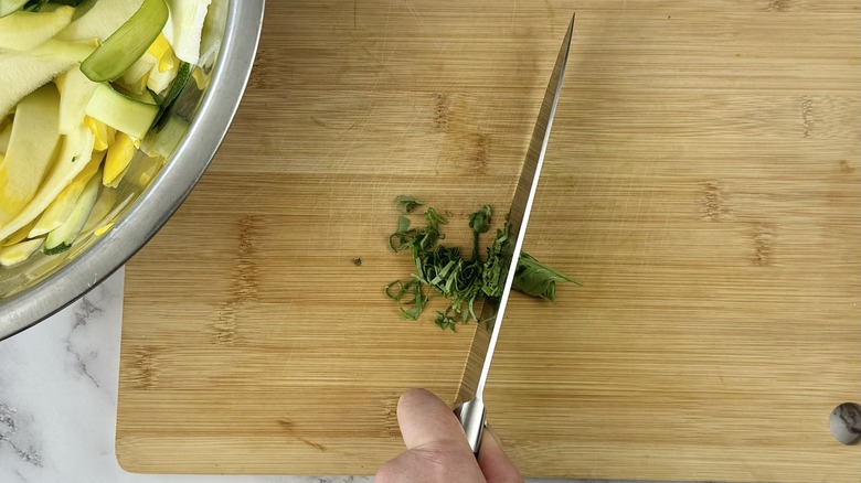 slicing basil on cutting board