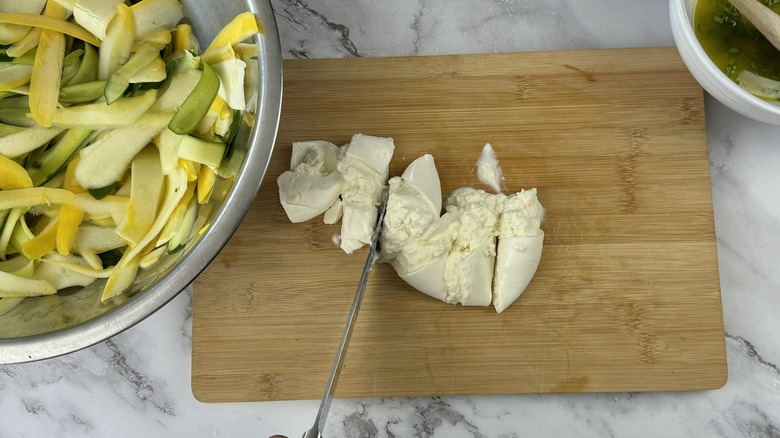 slicing burrata on cutting board