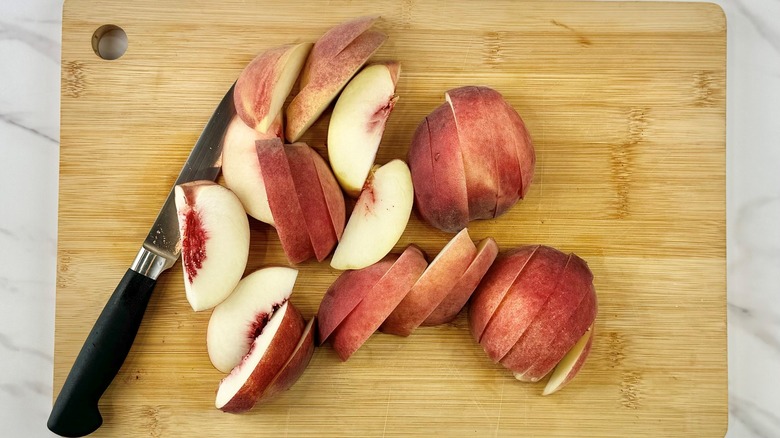 sliced peaches on cutting board