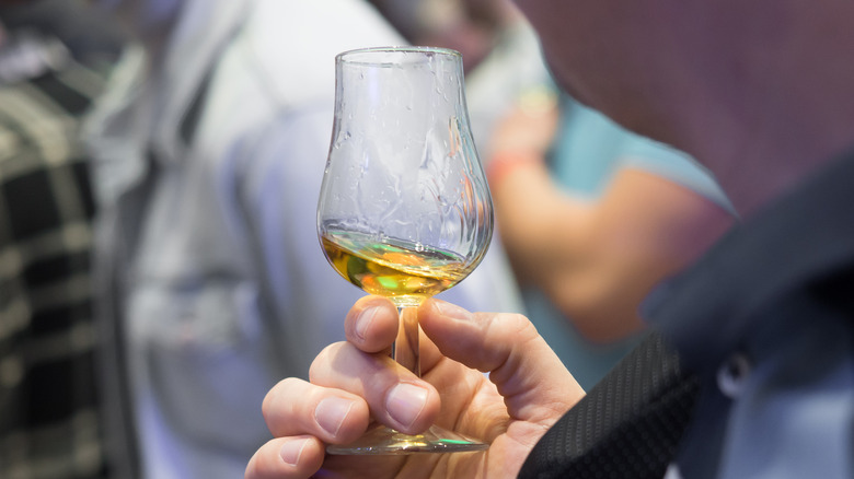 Person swirling whiskey in glass