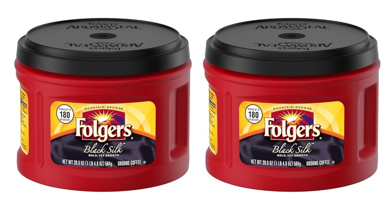 Two tubs of Folgers Black Silk dark roast coffee sitting side by side on a white background