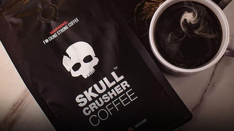 a top down view of a bag of Skull Crusher very strong coffee next to a steaming mug