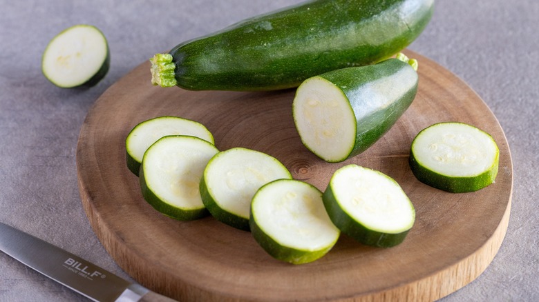 Zucchini sliced on wood cutting board