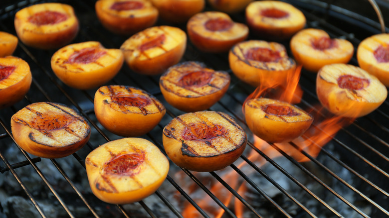 Halved peaches on flaming grill