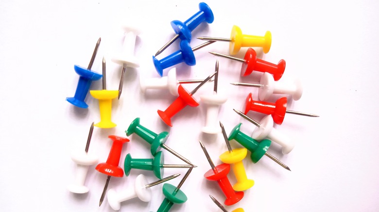 Colorful thumbtacks on white background