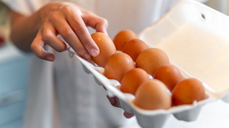 Someone taking eggs from a carton