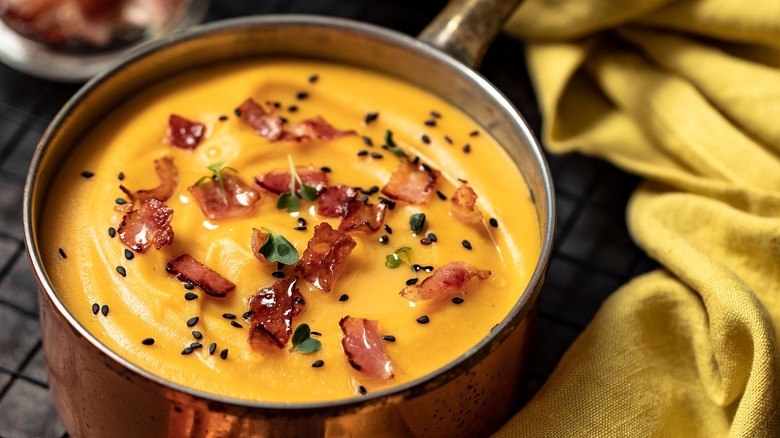 pumpkin soup with bacon and herbs on top