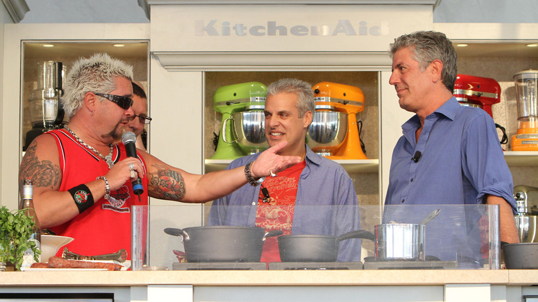 Guy Fieri gesturing with his hand out at Anthony Bourdain