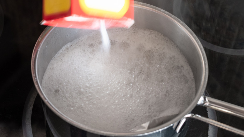Adding baking soda into pot of simmering water
