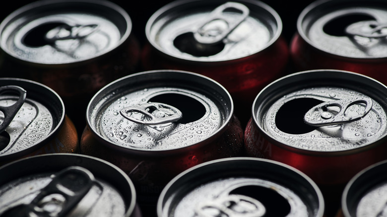 Several cans have open mouths and condensation