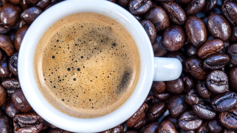 White coffee mug on robusta coffee beans