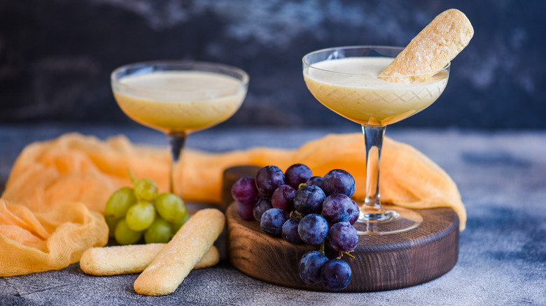 Zabaglione dessert in glasses surrounded by grapes and cookies