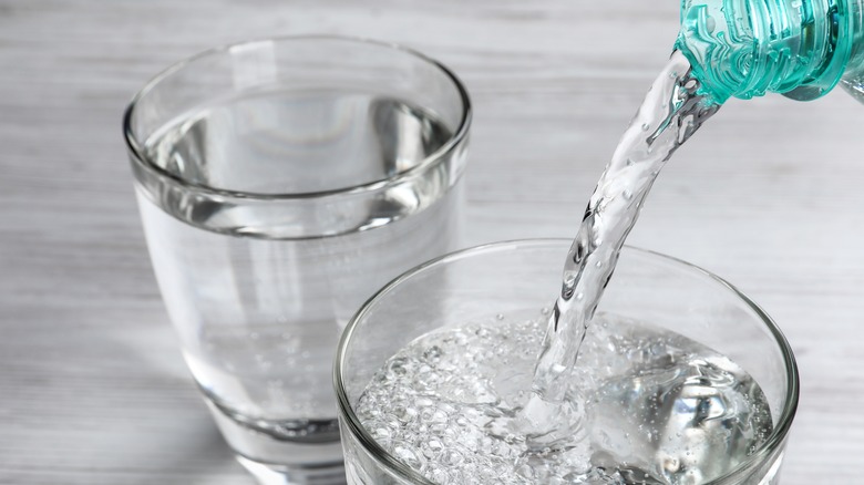 pouring carbonated water into glass