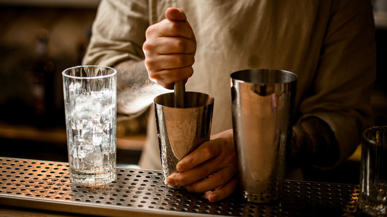 Muddling ingredients in a cocktail shaker