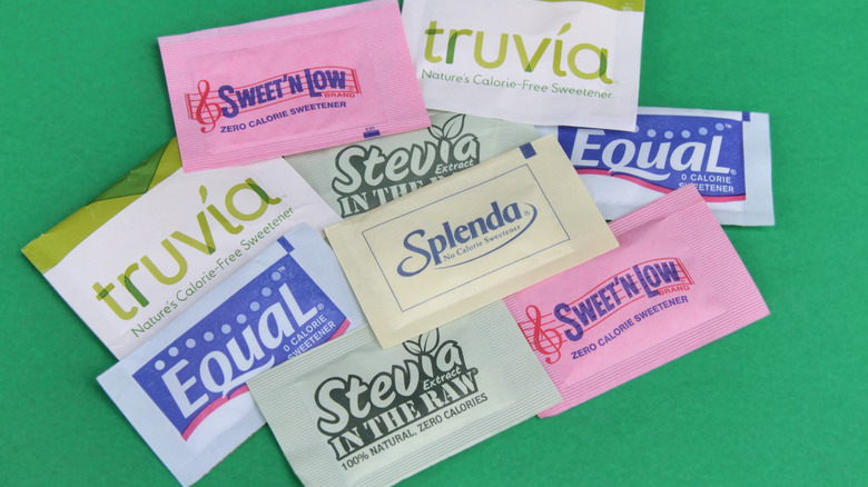 Artificial sweetener packets on green background