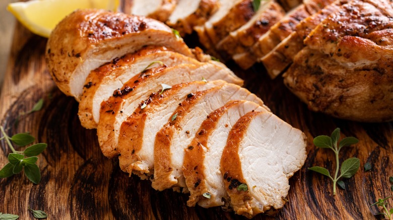 Juicy roasted chicken sliced on wood board