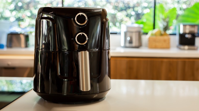 Black air fryer on kitchen countertop