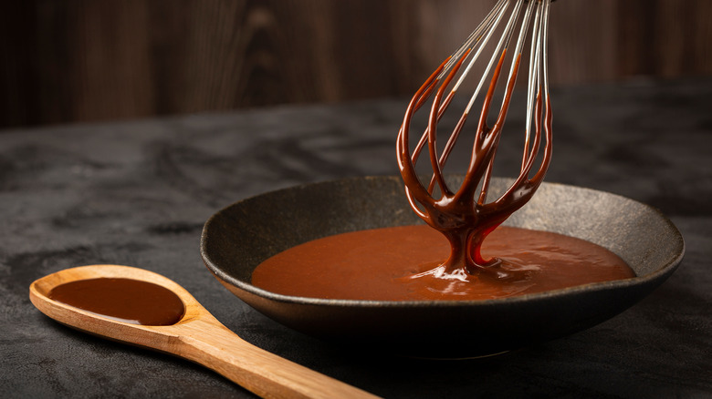 Melted chocolate with a whisk and a wooden spoon