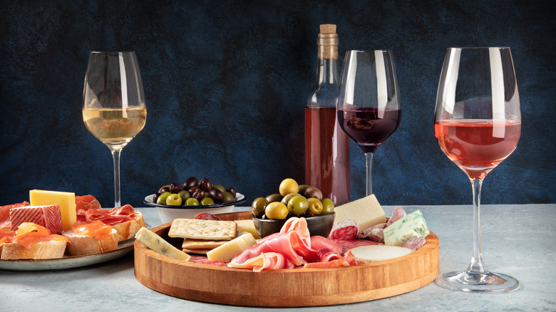 red, white, and rosé wines next to a charcuterie board